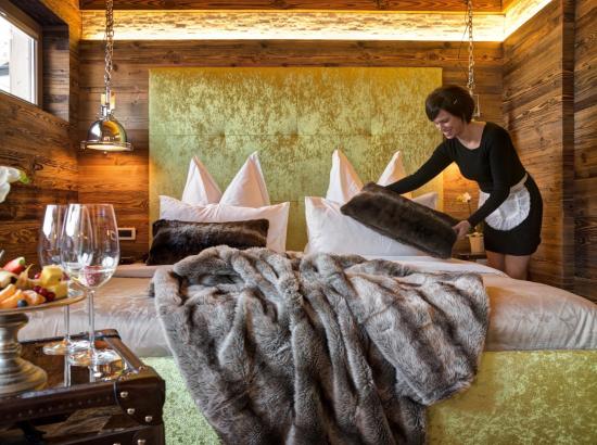Una cameriera ai piani sta facendo il letto del Chalet Design Alpin